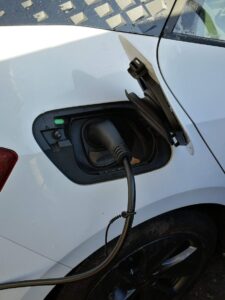 Charging cable plugged into a white electric car to ensure home charging